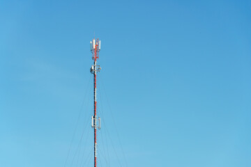 New GSM antennas on a high tower against a blue sky for transmitting a 5g signal are dangerous to health. Radiation pollution of the environment through cell towers. The threat of extinction