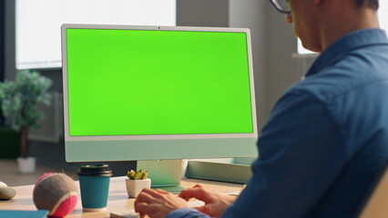 Freelancer using green screen computer in office close up. Business man working