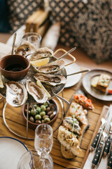 A plate of fresh oysters served with other snacks on a restaurant table
