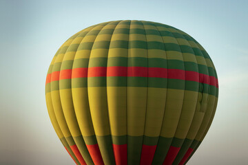 Hot balloon flying at sunset over the Atlas Mountains in the desert of Morocco 