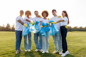 multiracial group of people volunteers in gloves with garbage bags collect garbage and plastic in the park