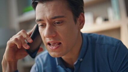 Angry guy shouting mobile phone closeup. Mad man calling cell at business place