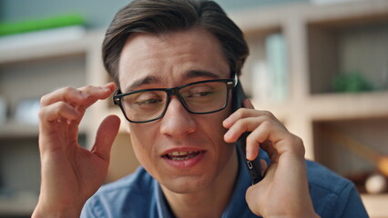 Closeup smiling businessman calling smartphone at office. Man mobile phone call