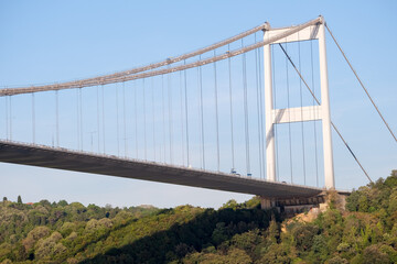 Fototapeta premium Bosphorus bridge photography from below angle with blue sky, forest and Turkish flag in İstanbul. 