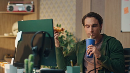 Hungry man drinking cola holding pizza office close up. Freelancer lunch break - obrazy, fototapety, plakaty