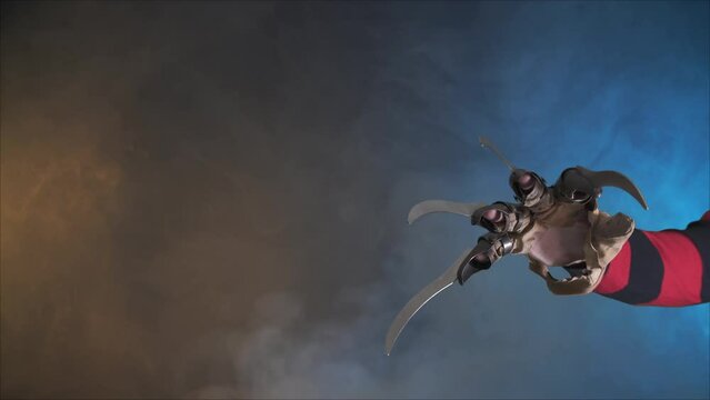 scary hand of  man is like a serial killer freddy with a glove sharp knives in the mist, background for Halloween