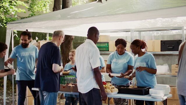 Youthful volunteers contributing to hunger alleviation through the provision of hot meals to the underprivileged. Humanitarian aid being provided to the poor, needy and homeless people.