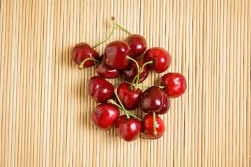 Red ripe red cherries with stem with clear bamboo cherry Picota Jerte background