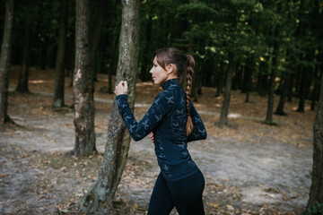 A photo of a beautiful young woman running in the park. Fresh air at forest. A healthy lifestyle