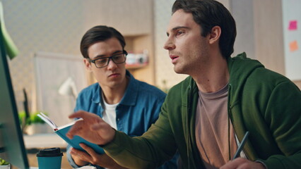 Two men brainstorming computer at business place closeup. Teamwork cooperation