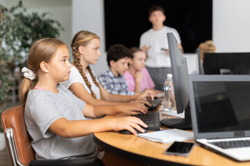 Portrait of female schoolgirl at computers in shool computer class