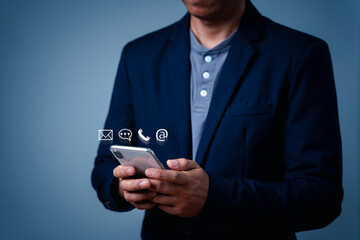 Businessman using smartphones, touch on virtual screen contact icons email, address, live chat, mobile phone via mobile app. Contact us or Customer support, the help center, and people connection