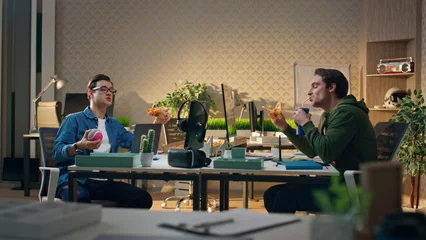 Zelfklevend Fotobehang Talking creators eating pizza together for lunch. Relaxed men enjoying dinner © stockbusters