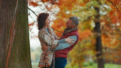 Hello autumn. smiling romantic family in the park hugging near tree.