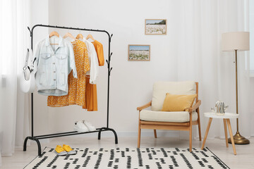 Stylish showroom interior with clothing rack and armchair