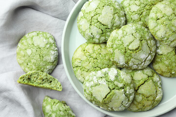 Plate with tasty matcha cookies on tablecloth, flat lay