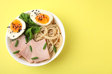 Delicious ramen with meat on pale yellow background, top view. Noodle soup. Space for text