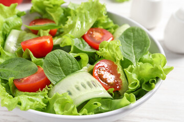 Delicious vegetable salad on white table, closeup