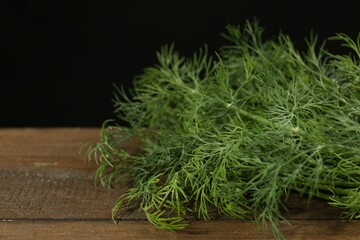 Fototapeta premium Fresh green dill on wooden table, closeup. Space for text
