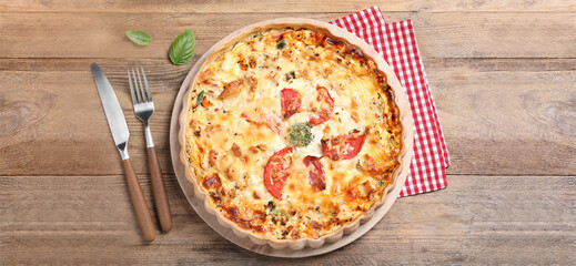 Tasty quiche with tomatoes and cheese served on wooden table, flat lay. Banner design