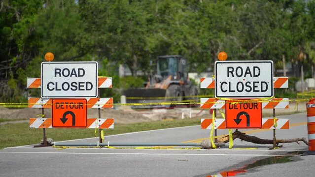 Yellow protective barrier at street construction site. Warning road sign about utility work