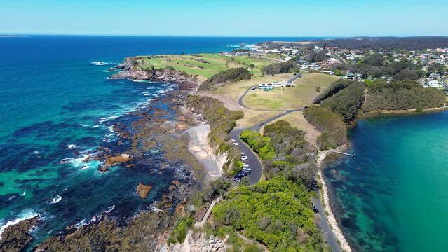 Drone aerial landscape shot carpark Wagonga head rocky coastline beach town suburb Narooma South Coast travel tourism NSW Australia 4K