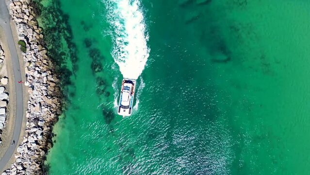 Drone aerial bird's-eye shot charter boat cruising crystal clear Wagonga inlet channel rock wall holiday destination travel tourism NSW South Coast Australia 4K