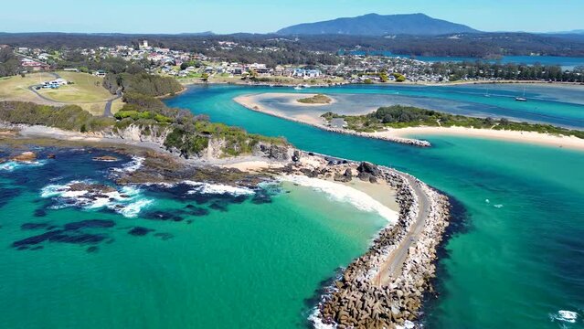 Drone aerial rock wall channel beach inlet channel coastline headland Narooma Wagonga beach travel tourism South Coast NSW Australia 4K