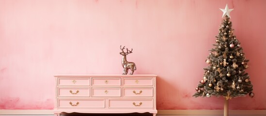Pink dresser with souvenir fawn and Christmas tree against pink wall