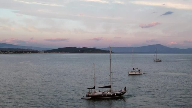 Aerial Drone view footage of old sailboat on quiet sea. Two-mast boat at sunset, with wind-board down, in Italy.  Mediterranean Sea, gulf of Gaeta. Holiday Vacation Sea Beach Summer Tourism