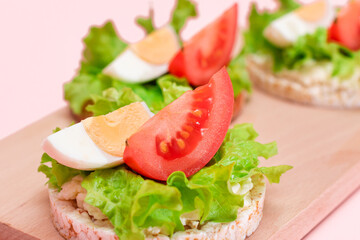 Rice Cake Sandwiches with Tomato, Lettuce and Egg on Wooden Cutting Board. Easy Breakfast. Diet Food. Quick and Healthy Sandwiches. Crispbread with Tasty Filling. Healthy Dietary Snack