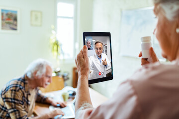 Senior Caucasian woman consulting her doctor about medication on a video call at home