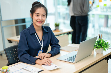 Young beautiful Asian businesswoman working at her office desk in the modern office room.