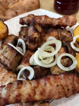 Falling rings of pickled onions on a barbecue grill of pork meat, ground beef. Slow motion video