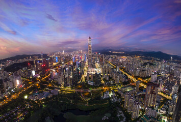 Drone fly over Shenzhen city central business district, aerial panorama China at night.