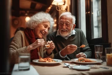 Poster Senior couple eating pizza in cafe © Stocknterias