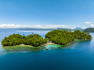 Aerial view of turquoise sea water and coral reefs in tropical island with resorts. Bangkay Island Resort. Mindanao, Philippines.