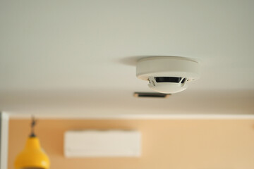 White smoke detector on ceiling at home 