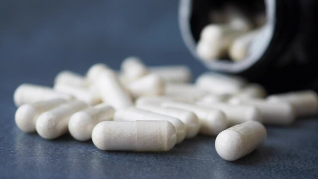 herbal medicine capsule dropping on table 