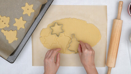 Woman hands making stamps on cookie dough. Step by step Christmas shortbread cookie recipe, close...