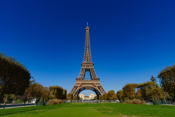 Eiffel Tower with Champs de Mars and sunny blue sky in Paris, France