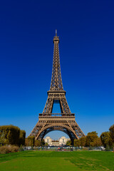 Eiffel Tower with Champs de Mars and sunny blue sky in Paris, France