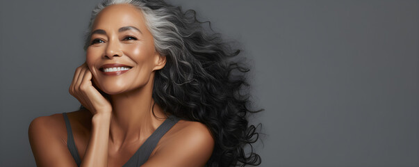 Black middle age woman portrait with healthy face skin. Open smiling beautiful aging mature woman with long hair. Beauty and cosmetics skincare advertising concept