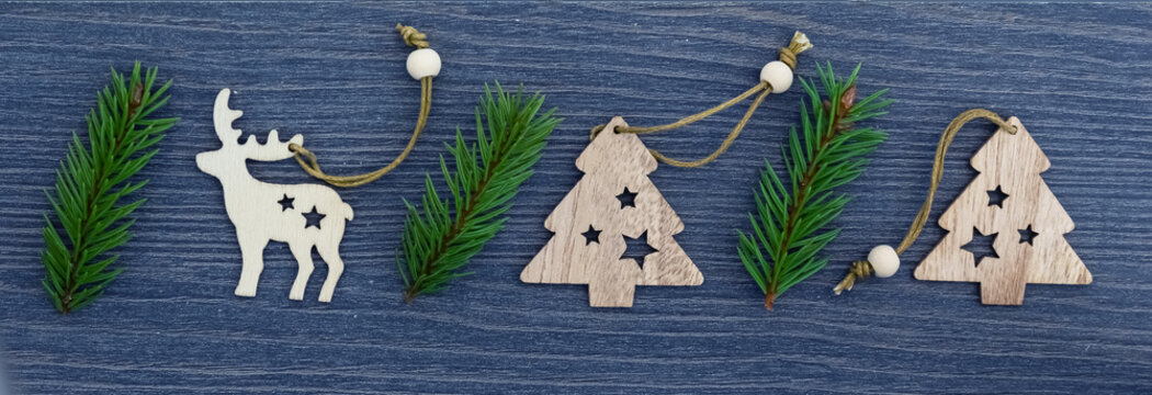 Wooden Christmas and new year toys on Christmas tree branches , top view, copy space, banner, holiday mood.