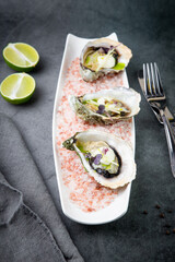 Grilled oysters on red sea salt with lime