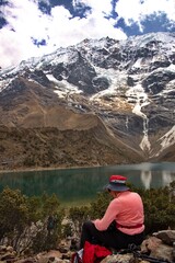 Fototapeta na wymiar Rear view of senior woman sitting on Humantay lake in Peru