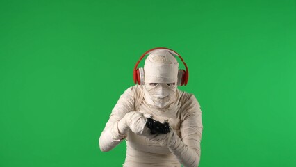 Green screen isolated chroma key photo capturing a mummy wearing headphones and holding a gamepad...