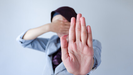 People, body language. Young Muslim woman covers eyes with palm and doing stop gesture, tries to...