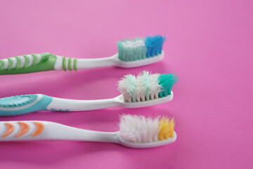 Three used, old toothbrushes on pink background. Concept, tool for brush teeth. Need to change new...