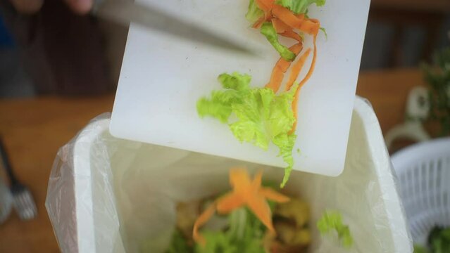 Ecology compost supply kitchen waste sorting waste vegetable peels from cutting board to recycle composter environmentally friendly. Man throws leftover fruit peel and vegetables reduce zero waste.